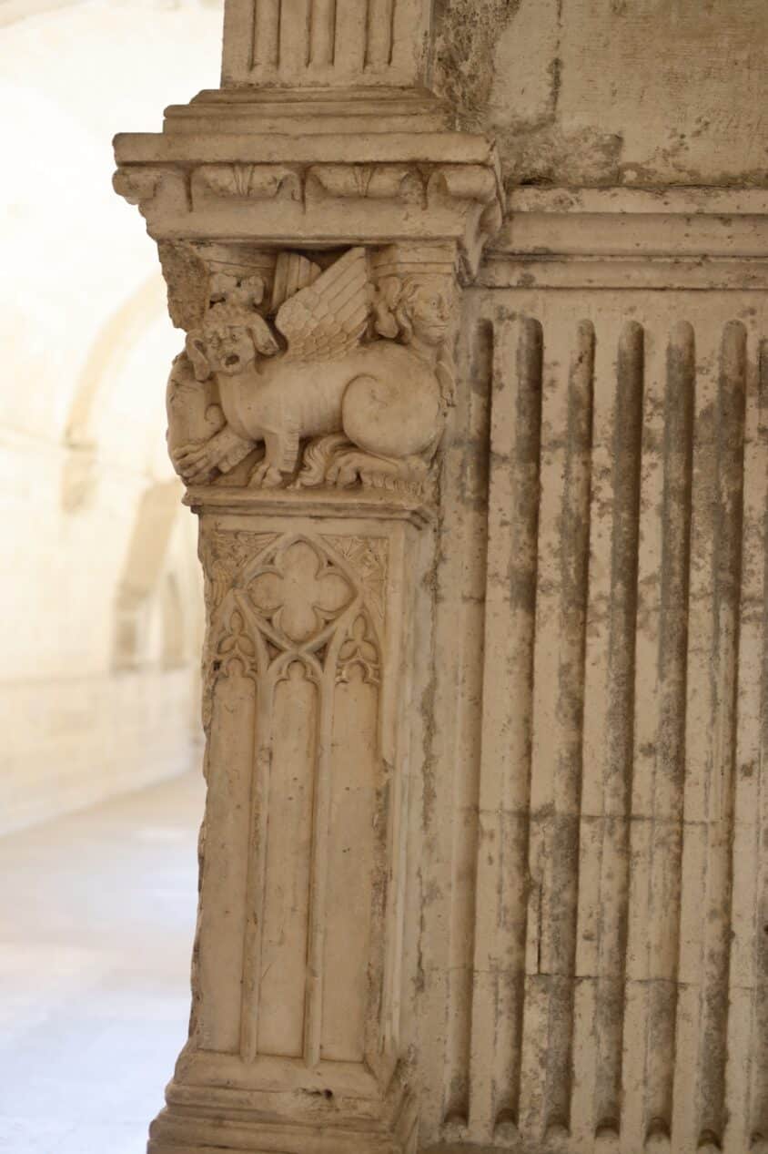 A winged beast above Gothic tracery.